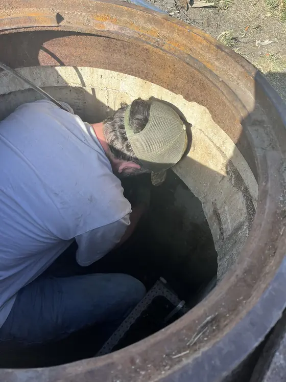 Técnico de Act Now Pros trabajando dentro de una cámara de estación elevadora comercial