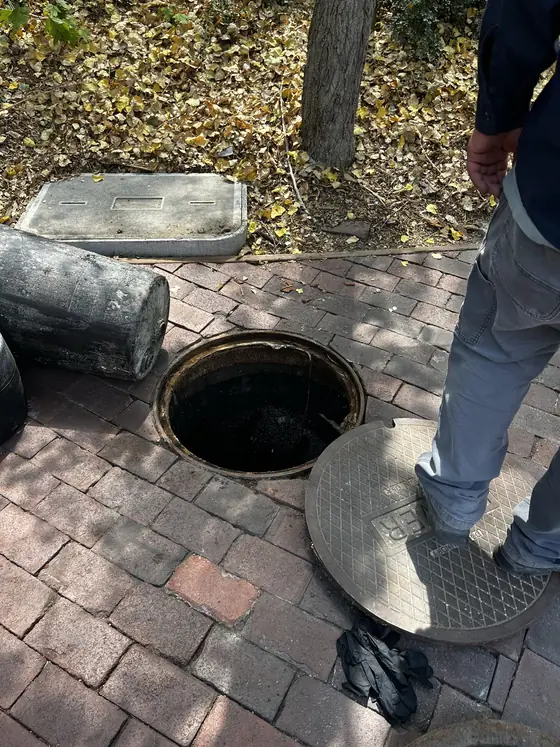 Técnico trabajando dentro de una cámara de servicio circular con una escalera