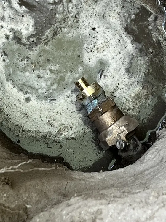Manguera de bombeo y conos cerca de un acceso de servicio en una estación de combustible