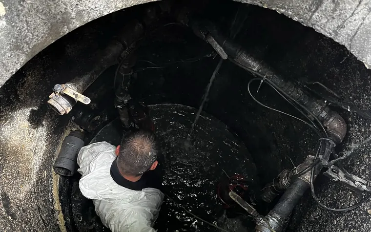 Técnico trabajando dentro de una cámara de bombeo